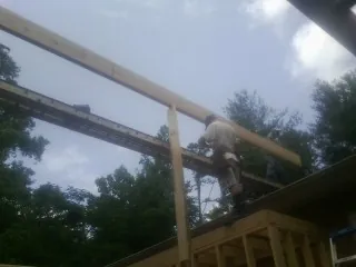 Carpenter setting a ridge beam over a new addition frame — Ice Dam Removal by Roofing Brothers in Rancho Cucamonga