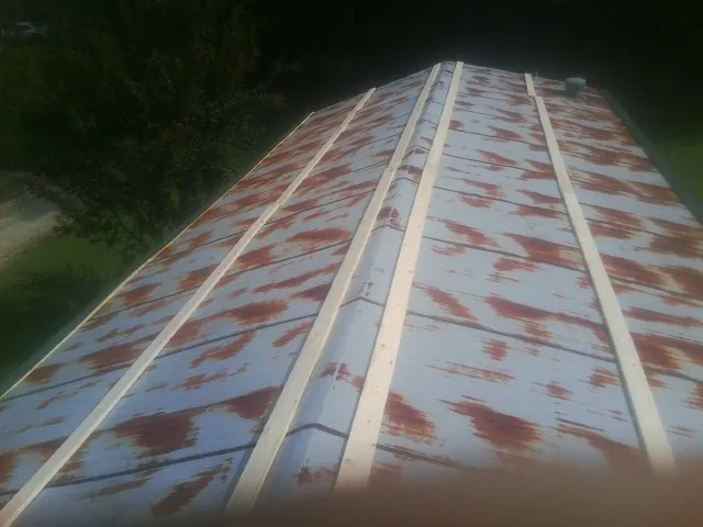 Rusted metal roof panels with new wood purlins before replacement — Storm Damage Roof Repair in Rancho Cucamonga by Roofing Brothers
