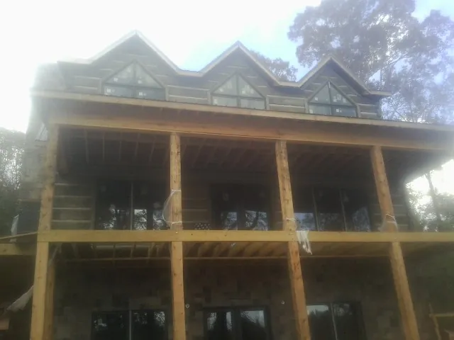 Dormers and porch framing on a large log home under construction — Roof Coating work by our crew in Rancho Cucamonga