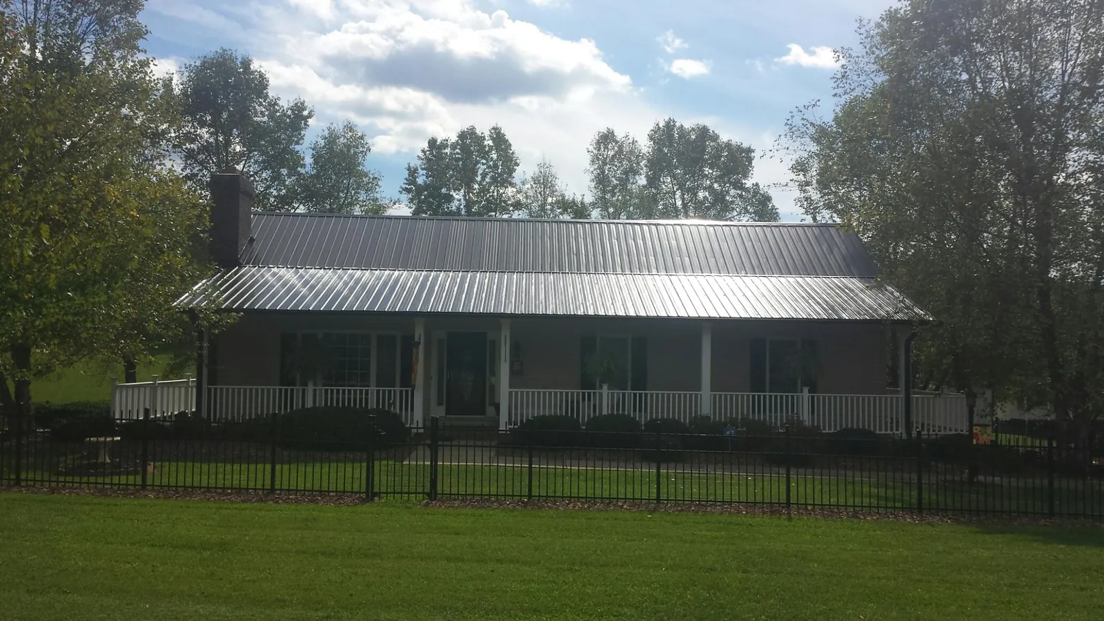 Gray metal roof on a brick ranch with a full width front porch — Gutter Guard Installation work by our crew in Rancho Cucamonga