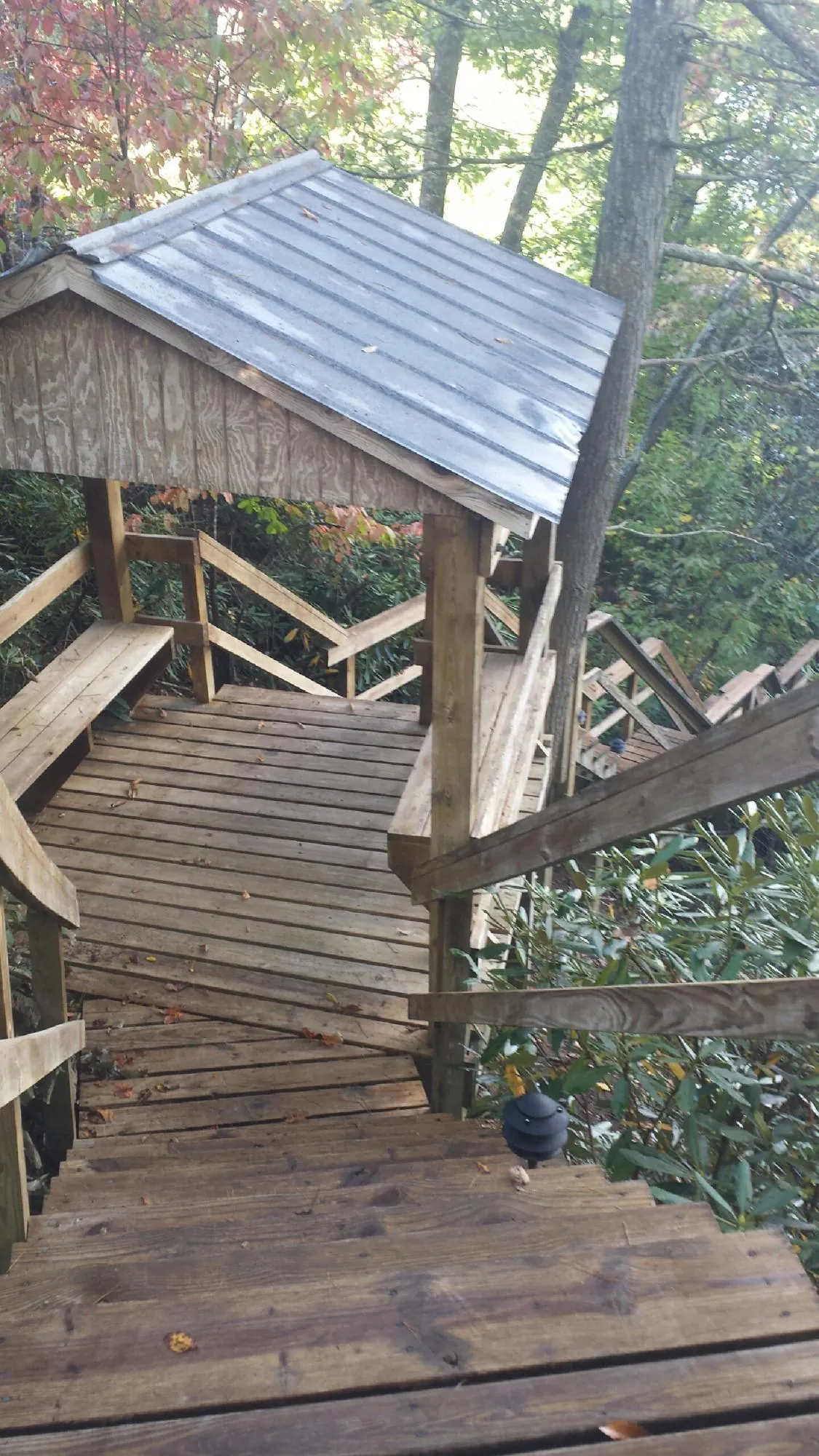 Metal roofed shelter over wooden steps on a wooded walkway — Skylight Repair & Installation work by our crew in Rancho Cucamonga